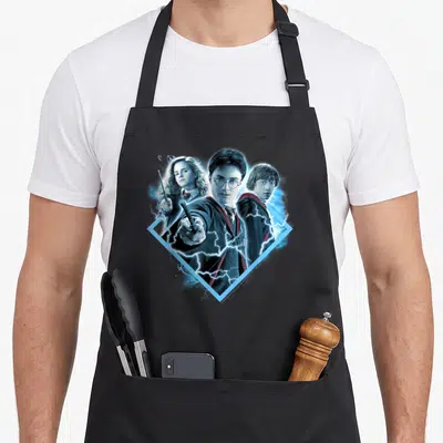Granger potter apron - Harry, Hermione, and Ron in blue diamond with lightning bolts photo art — shown on a black cotton canvas apron against a white background