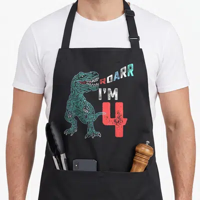 4th dinosaur apron - Teal line-art T-Rex next to stacked ROARR I'M 4 text in red and white — shown on a black cotton canvas apron against a white background