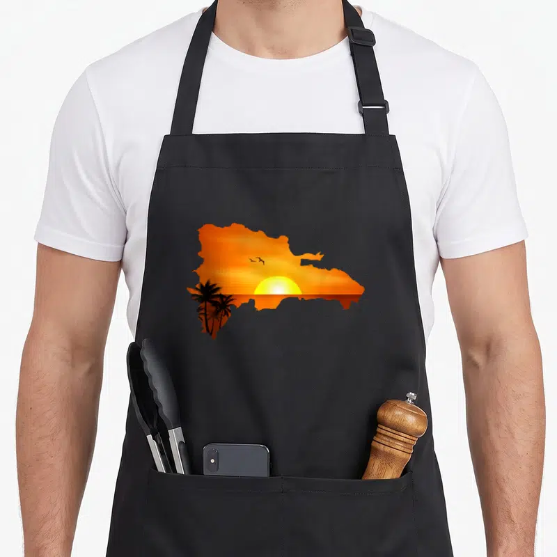 Domrep santo domingo apron - Silhouette of Dominican Republic map filled with orange sunset, yellow sun, black palm — shown on a black cotton canvas apron against a white background