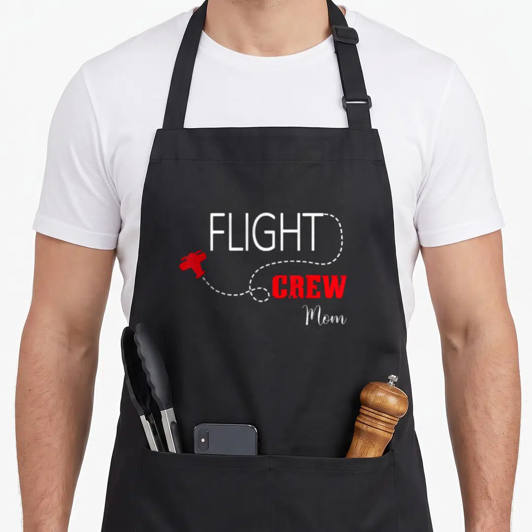 Flight crew aprons - Red airplane trailing white dotted line around white and red FLIGHT CREW Mom text — shown on a black cotton canvas apron against a white background