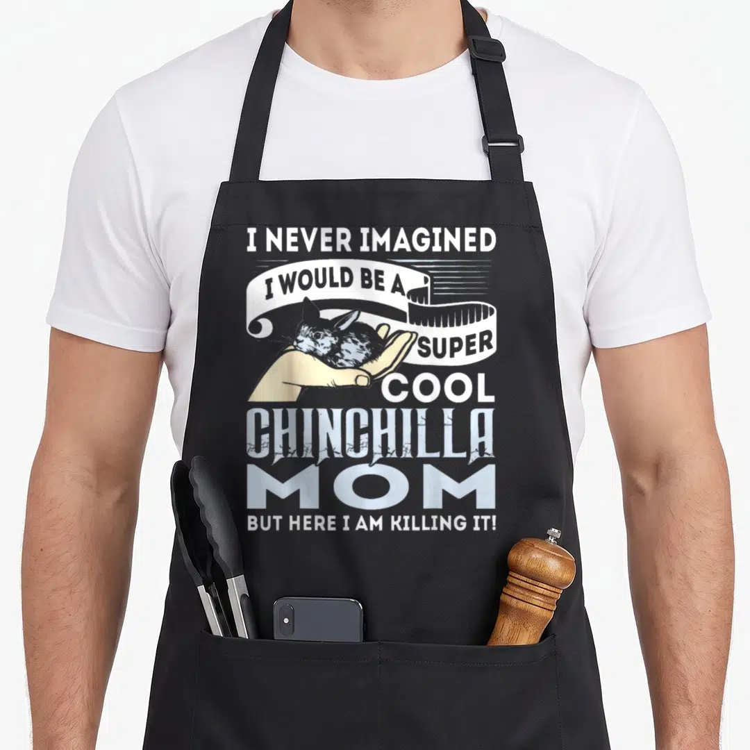 Imagined chinchilla mom apron - Distressed text I NEVER IMAGINED I WOULD BE A SUPER COOL CHINCHILLA MOM around — shown on a black cotton canvas apron against a white background