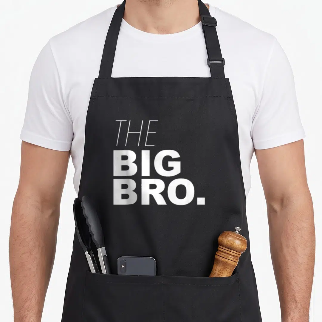 Brother buddy read apron - White stacked text reading THE BIG BRO in bold sans-serif font — shown on a black cotton canvas apron against a white background