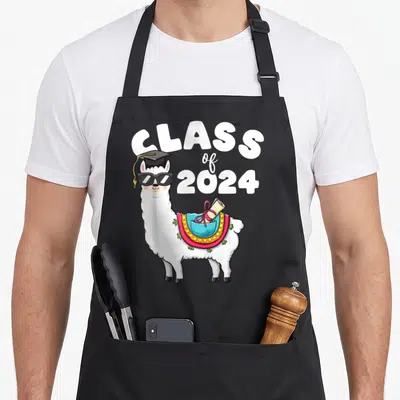 Llama class apron - Cartoon white llama in graduation cap and sunglasses with diploma saddle and CLASS of 2024 text — shown on a black cotton canvas apron against a white background