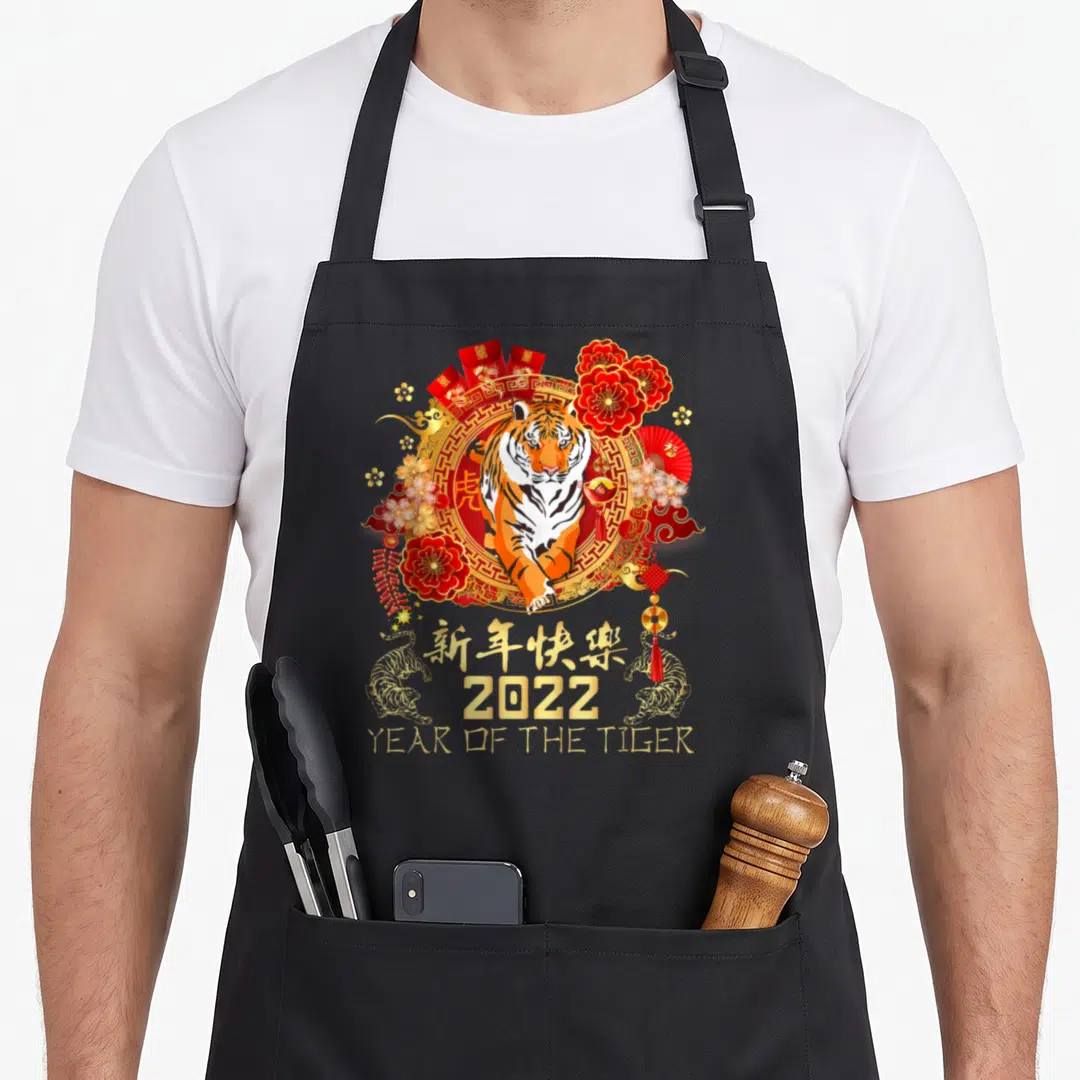 Chinese vietnamese girl apron - Realistic tiger in red gold circle with 2022 Year of the Tiger text and floral fans — shown on a black cotton canvas apron against a white background