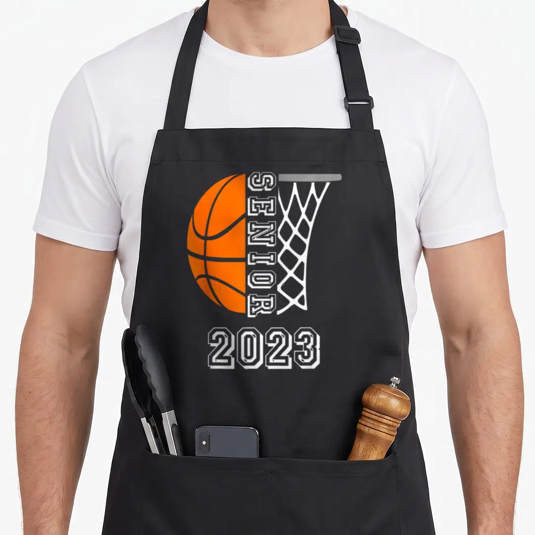 Graduate class player apron - Orange basketball and white net with vertical SENIOR and centered 2023 text — shown on a black cotton canvas apron against a white background