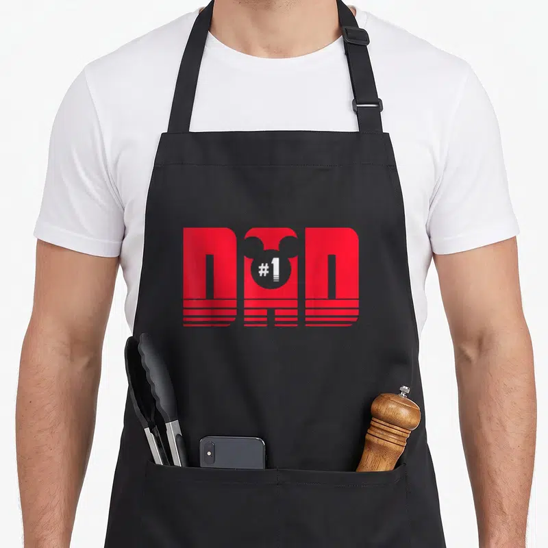 Cute mouse dad apron - Red stylized DND graphic with white #1 in a circle and horizontal stripes — shown on a black cotton canvas apron against a white background
