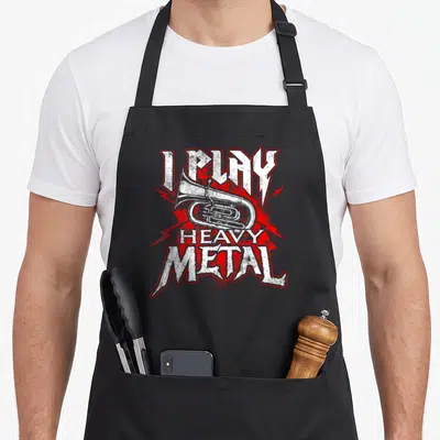 Play heavy metal apron - Tuba illustration with I Play Heavy Metal text and red lightning bolts — shown on a black cotton canvas apron against a white background