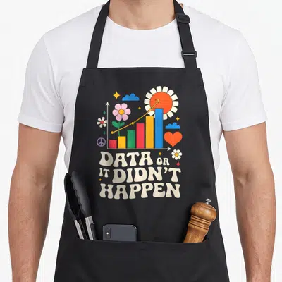 Data apron or apron - Retro bar chart with flowers and DATA OR IT DIDNT HAPPEN text — shown on a black cotton canvas apron against a white background