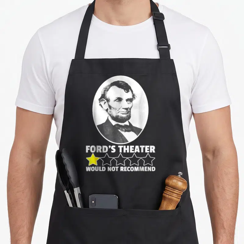 Ford theater apron - Lincoln portrait oval with Ford's Theater text and one yellow star rating — shown on a black cotton canvas apron against a white background