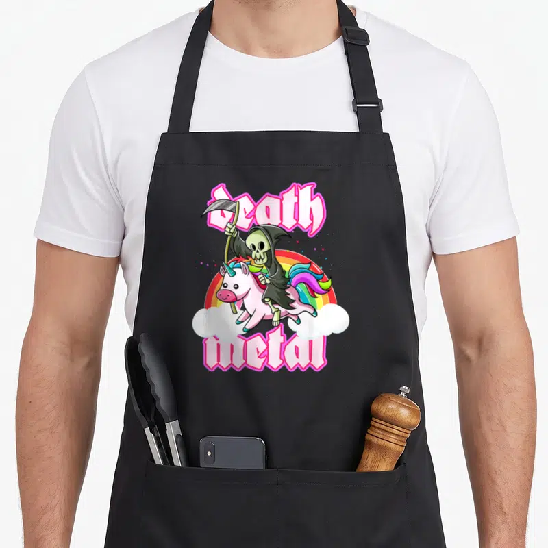 Blackcraft unicorn apron - Grim Reaper riding pink unicorn with rainbow and Death Metal text — shown on a black cotton canvas apron against a white background