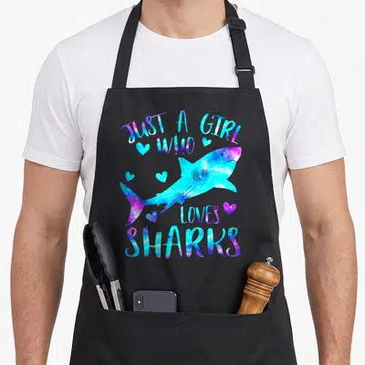 Shark theme aprons - Galaxy style shark with blue purple pink text and scattered hearts — shown on a black cotton canvas apron against a white background