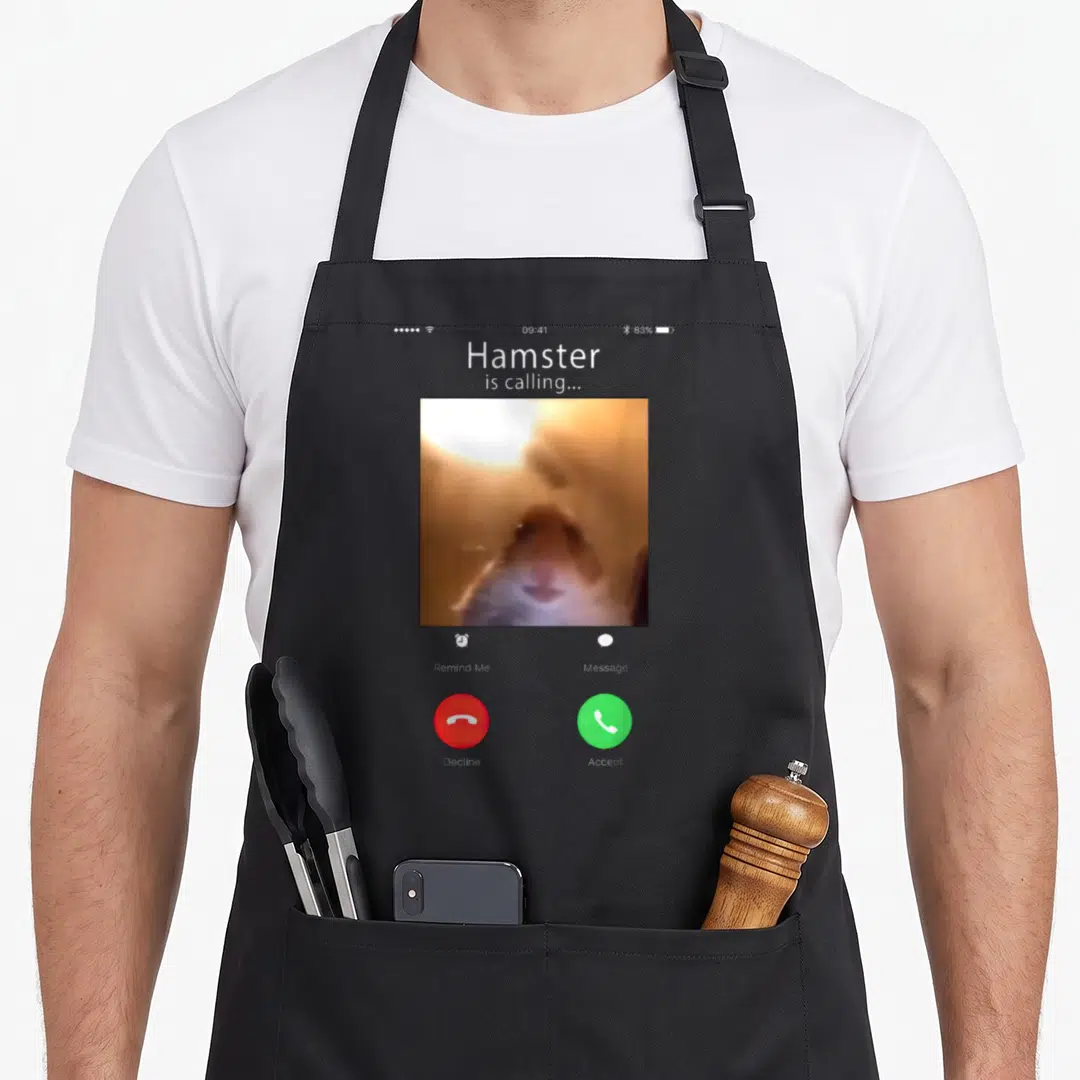 Dank meme apron - Smartphone call screen with blurry brown hamster photo, grey background, red and green buttons — shown on a black cotton canvas apron against a white background