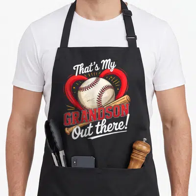 Vintage baseball grandma apron - Red heart baseball tan bat That's My Grandson Out there cartoon text — shown on a black cotton canvas apron against a white background