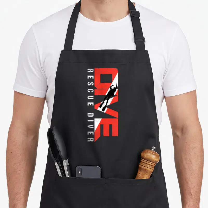 Scuba student aprons - Vertical red DIVE text with black diver silhouette and white Rescue Diver text on distressed — shown on a black cotton canvas apron against a white background