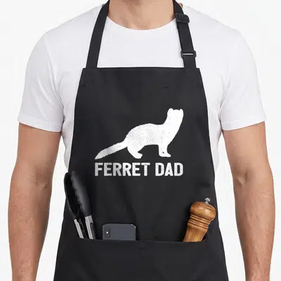 Ferret dad apron for mom - Distressed white ferret silhouette standing above blocky FERRET DAD text on dark background — shown on a black cotton canvas apron against a white background