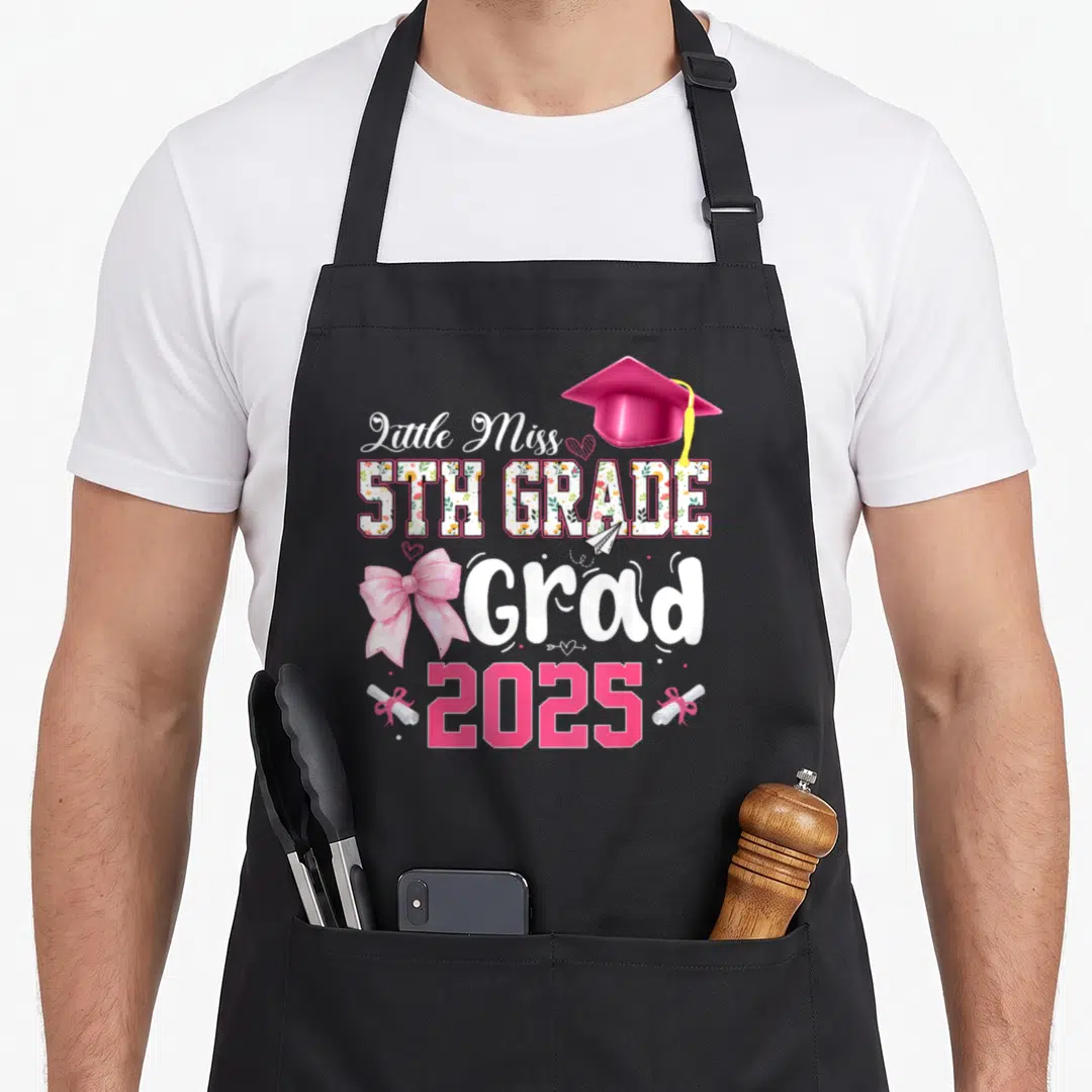 5th bow apron - Little Miss 5th Grade Grad 2025 with pink cap, bow, and floral text — shown on a black cotton canvas apron against a white background