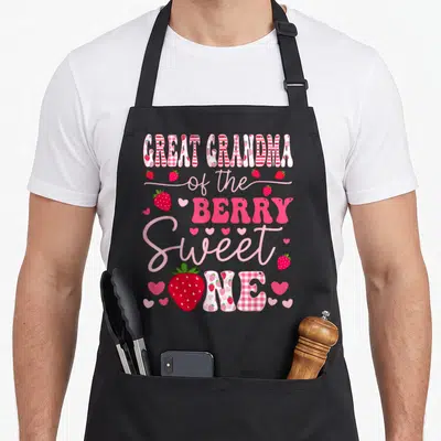 Berry great grandma apron - Stacked text reading Great Grandma of the Berry Sweet One surrounded by red strawberries — shown on a black cotton canvas apron against a white background