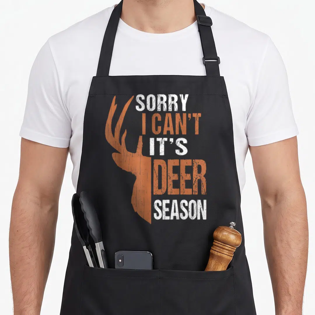 Sorry father day apron - Deer head silhouette beside stacked text sorry i can t its deer season in orange and white — shown on a black cotton canvas apron against a white background