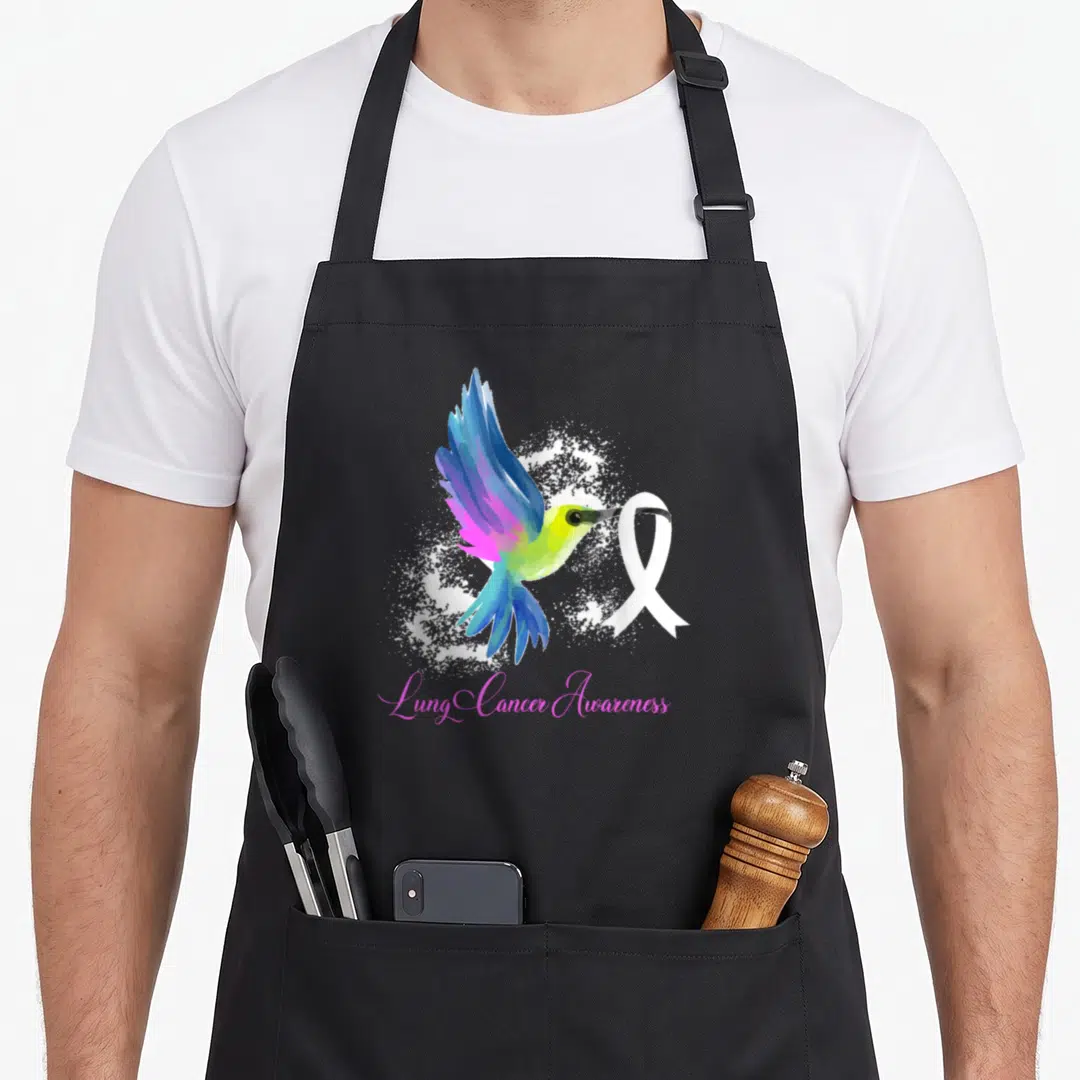 Cancer survivor ribbon apron - Watercolor hummingbird holding white ribbon above pink Lung Cancer Awareness text — shown on a black cotton canvas apron against a white background
