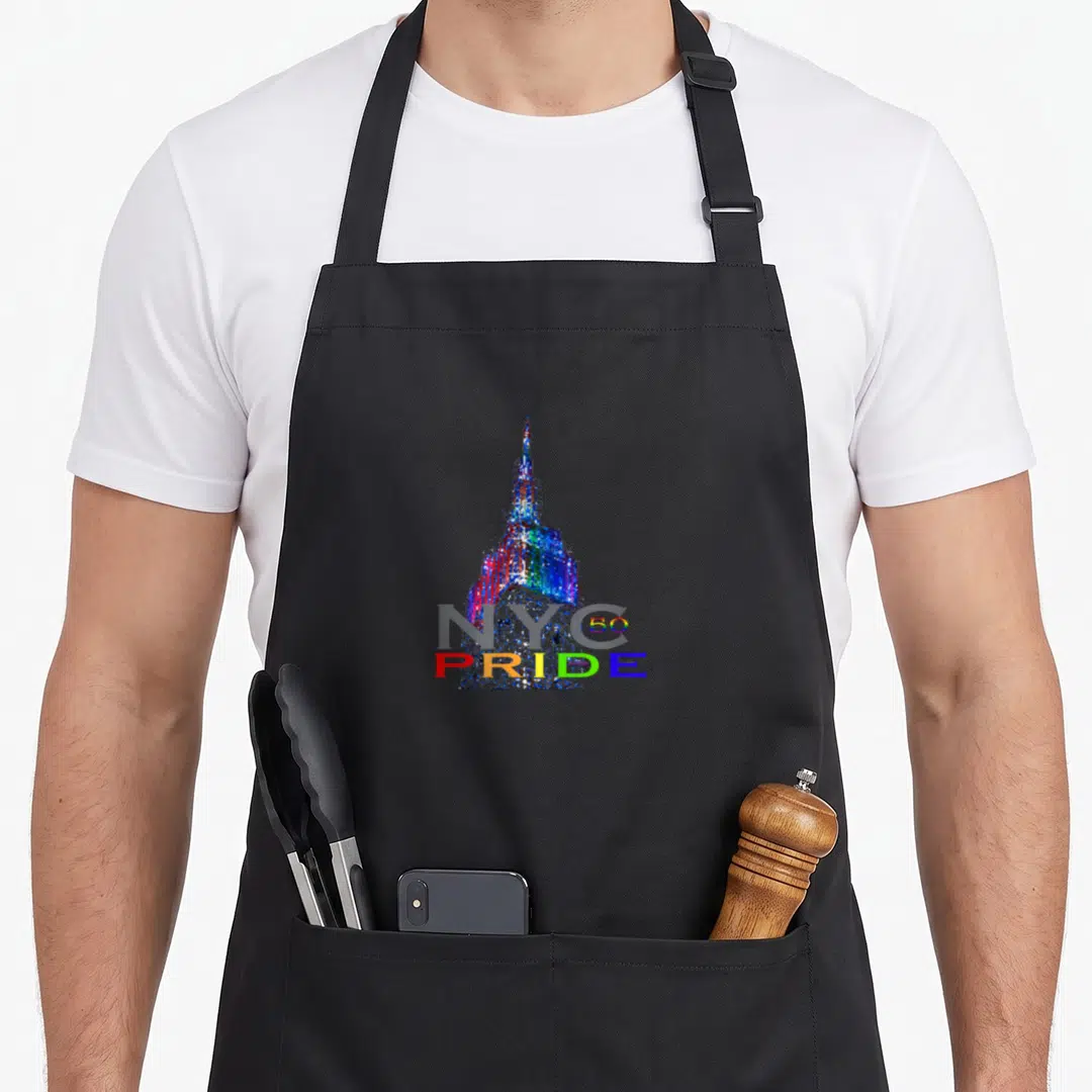 Commemorative new york apron - Rainbow Empire State Building with grey NYC text and colorful 50 PRIDE lettering — shown on a black cotton canvas apron against a white background