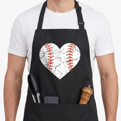 Sport player baseball apron - White heart shaped like a baseball with two red stitching rows on black fabric — shown on a black cotton canvas apron against a white background