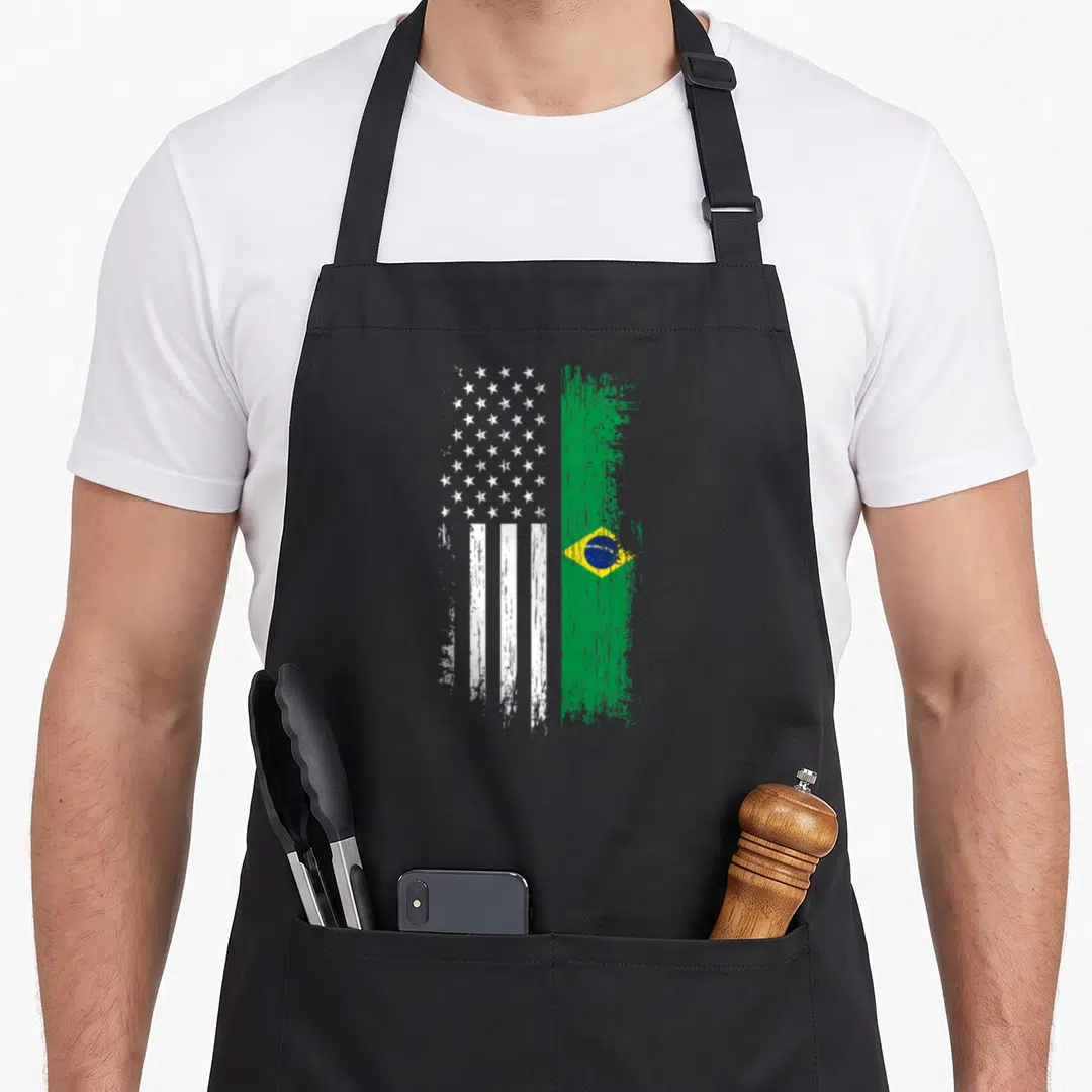 Brazilian pride american flag apron - Vertical split USA and Brazil flag design with distressed paint strokes in white — shown on a black cotton canvas apron against a white background