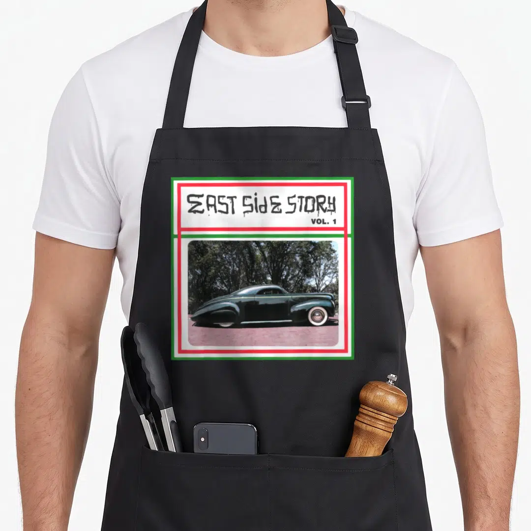 Mercury 1940s apron - EAST SIDE STORY text above green lowrider car in red white green border — shown on a black cotton canvas apron against a white background