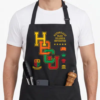 Hbcu jay college apron - Interlocking HBCU letters with shield reading Educated and column of academic symbols — shown on a black cotton canvas apron against a white background