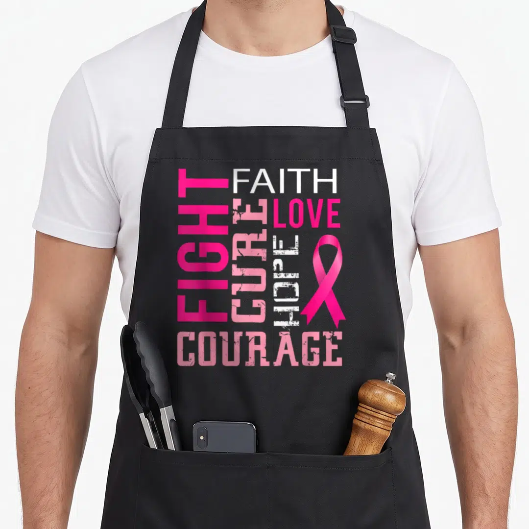 Faith breast cancer awareness aprons - Pink and white typography with FIGHT FAITH CURE LOVE HOPE COURAGE and ribbon — shown on a black cotton canvas apron against a white background