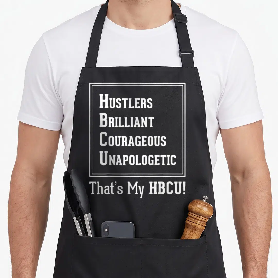 Proud unapologetic apron - White text HUSTLERS BRILLIANT COURAGEOUS UNAPOLOGETIC That's My HBCU! on black background — shown on a black cotton canvas apron against a white background