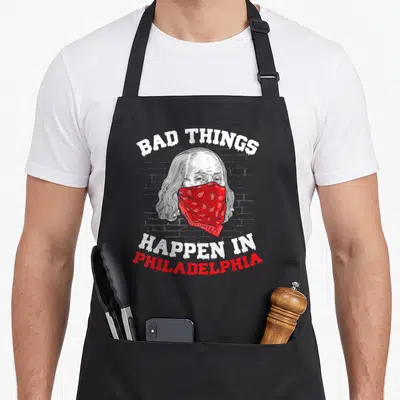 Presidential philadelphia apron - Benjamin Franklin head with red bandana and bad things happen in philadelphia text — shown on a black cotton canvas apron against a white background