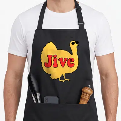 Jive thanksgiving aprons - Cartoon yellow turkey wearing black sunglasses with red Jive text on body — shown on a black cotton canvas apron against a white background
