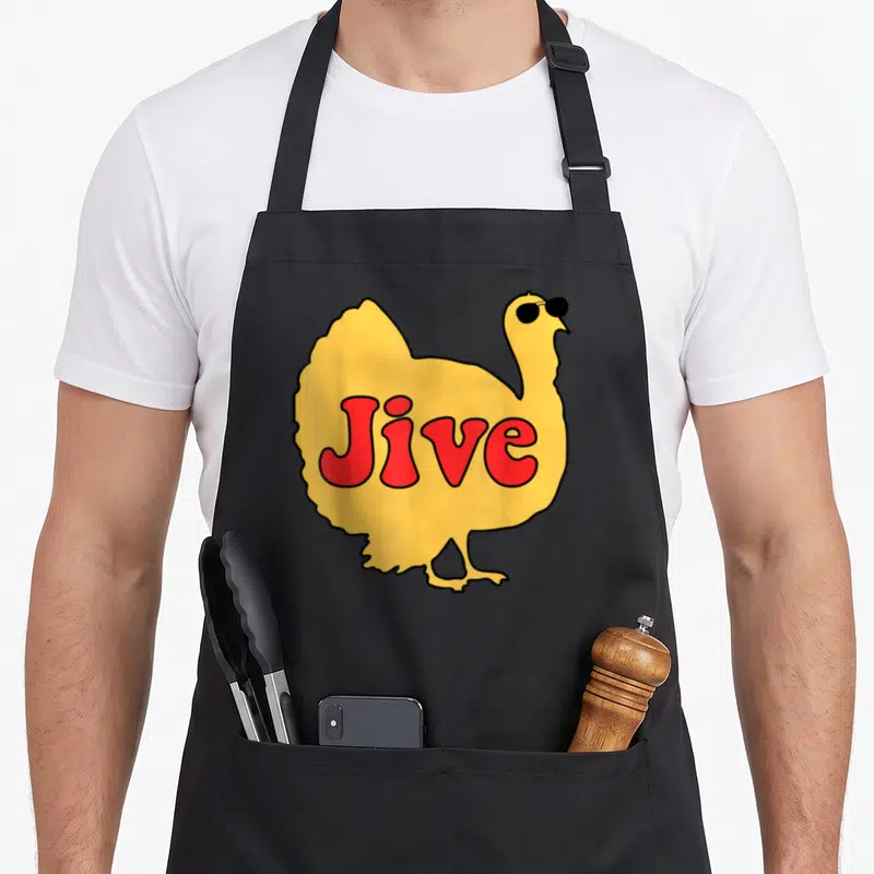 Jive thanksgiving aprons - Cartoon yellow turkey wearing black sunglasses with red Jive text on body — shown on a black cotton canvas apron against a white background