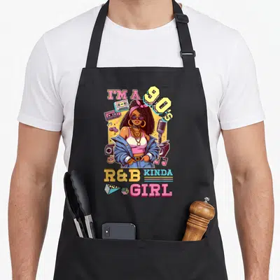 90s hip apron - Cartoon woman with sunglasses surrounded by cassettes and microphone, 90s text — shown on a black cotton canvas apron against a white background