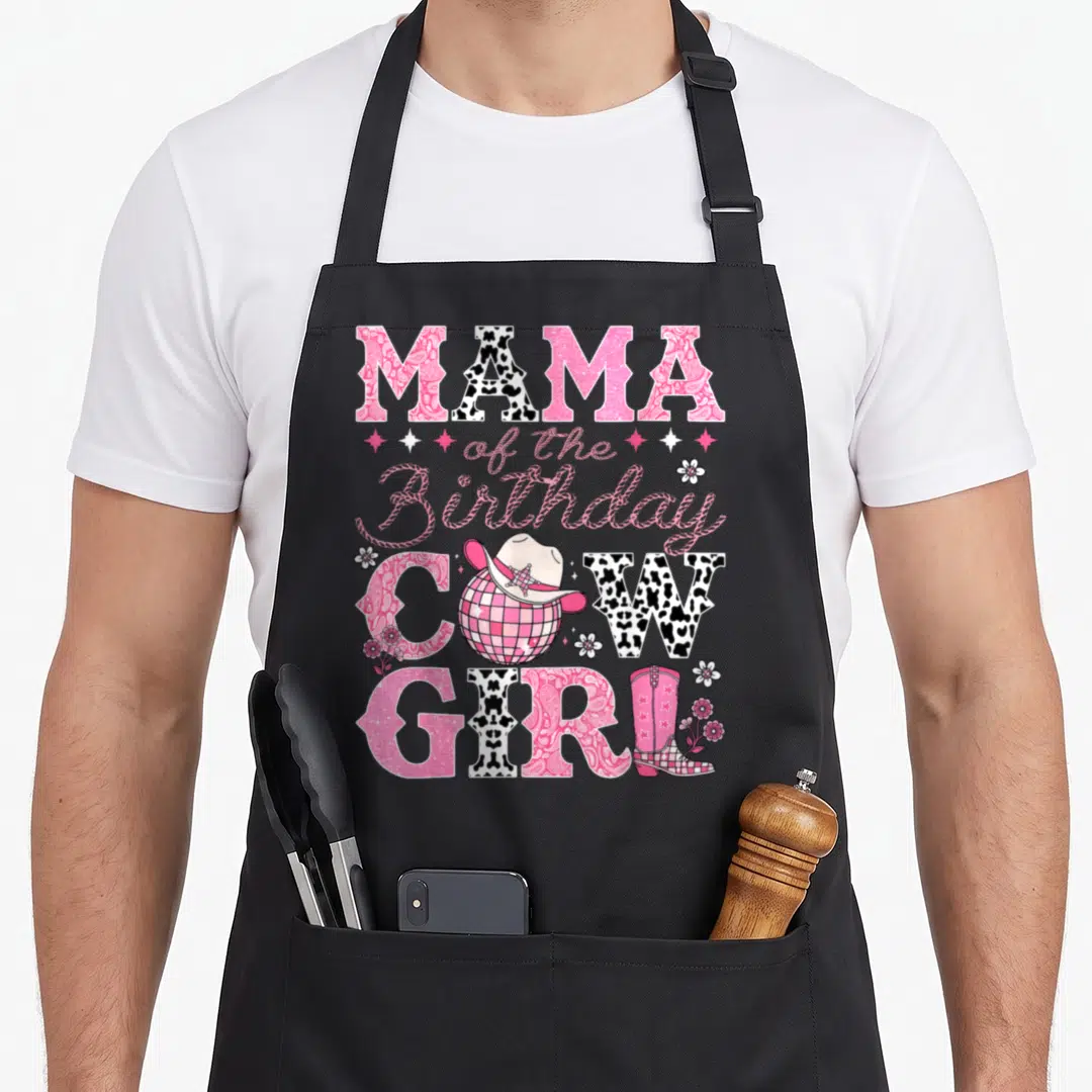 Bday cowgirl aprons - Mama of the Birthday Cowgirl text with disco ball cowboy hat and pink boot in pink and black — shown on a black cotton canvas apron against a white background
