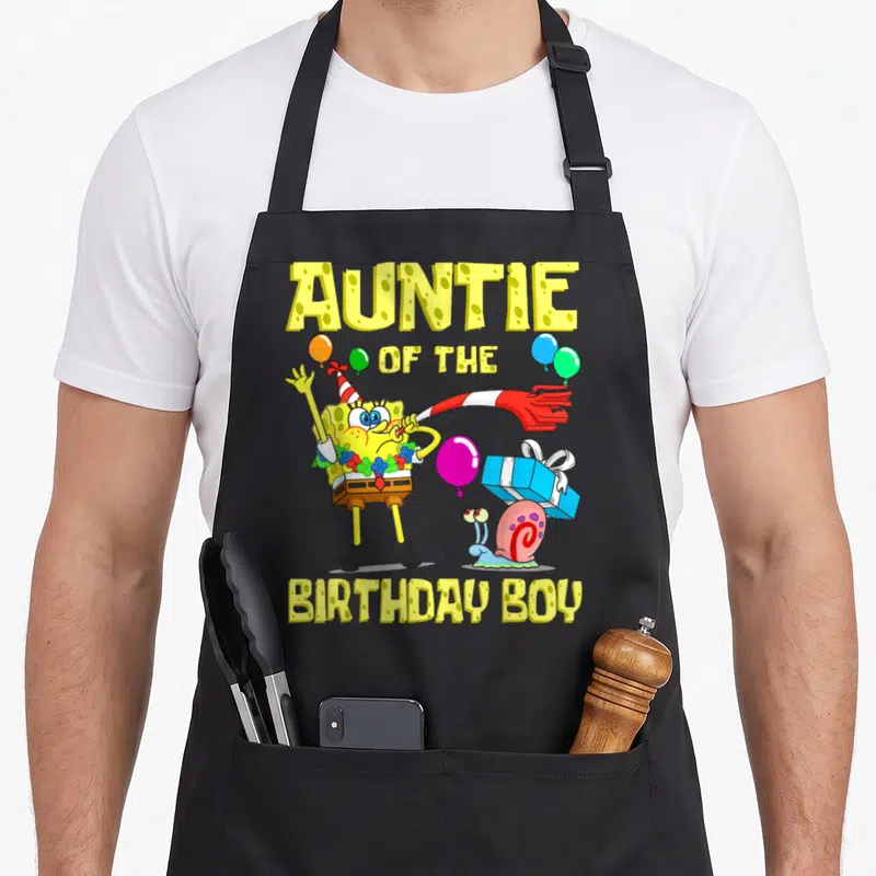 Auntie birthday apron - SpongeBob SquarePants with party hat, balloons, gift, and text Auntie of the Birthday Boy — shown on a black cotton canvas apron against a white background