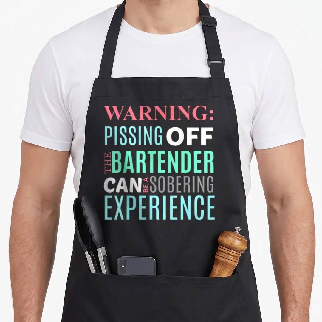 Sarcastic bartender apron - Stacked text reading WARNING PISSING OFF THE BARTENDER CAN BE A SOBERING EXPERIENCE in pink — shown on a black cotton canvas apron against a white background