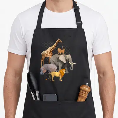 Safari african apron - Cartoon giraffe, elephant, monkey, lion, and hippo in grey orange brown yellow with halftone dots — shown on a black cotton canvas apron against a white background