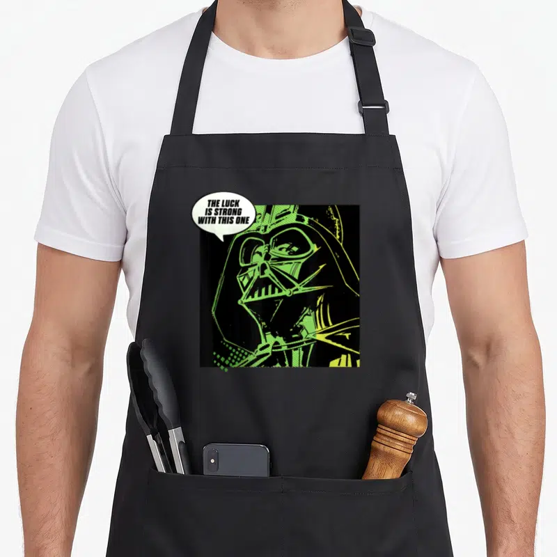 Luck st patrick day aprons - Retro Darth Vader portrait in black and lime green with speech bubble text — shown on a black cotton canvas apron against a white background