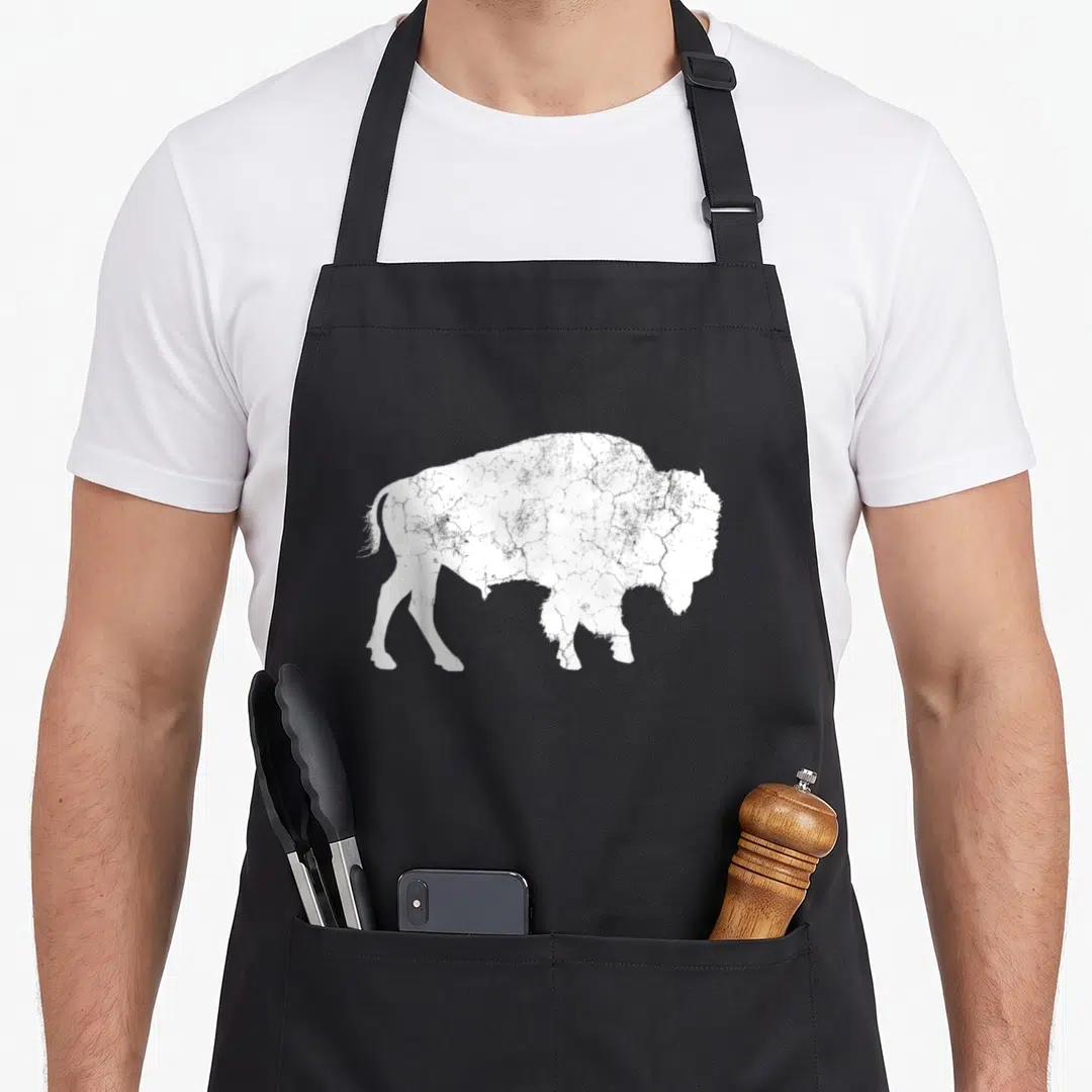 Distressed animal apron - White distressed bison silhouette on black bib apron — shown on a black cotton canvas apron against a white background