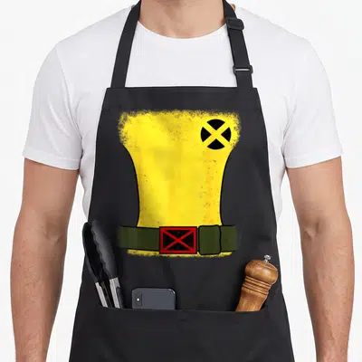 Rogue halloween white apron - Yellow torso shape with black circle and olive green belt with red buckle on black fabric — shown on a black cotton canvas apron against a white background