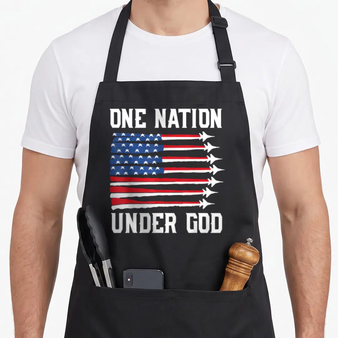 Nation god 4th of july apron - ONE NATION UNDER GOD text above and below a flag made of eight jet contrails in red — shown on a black cotton canvas apron against a white background