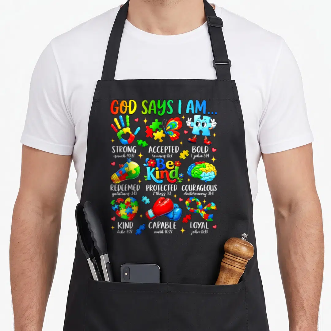 Kind god says i am apron - Colorful puzzle pieces, boxing gloves, brain, and scripture verses arranged in a grid layout — shown on a black cotton canvas apron against a white background