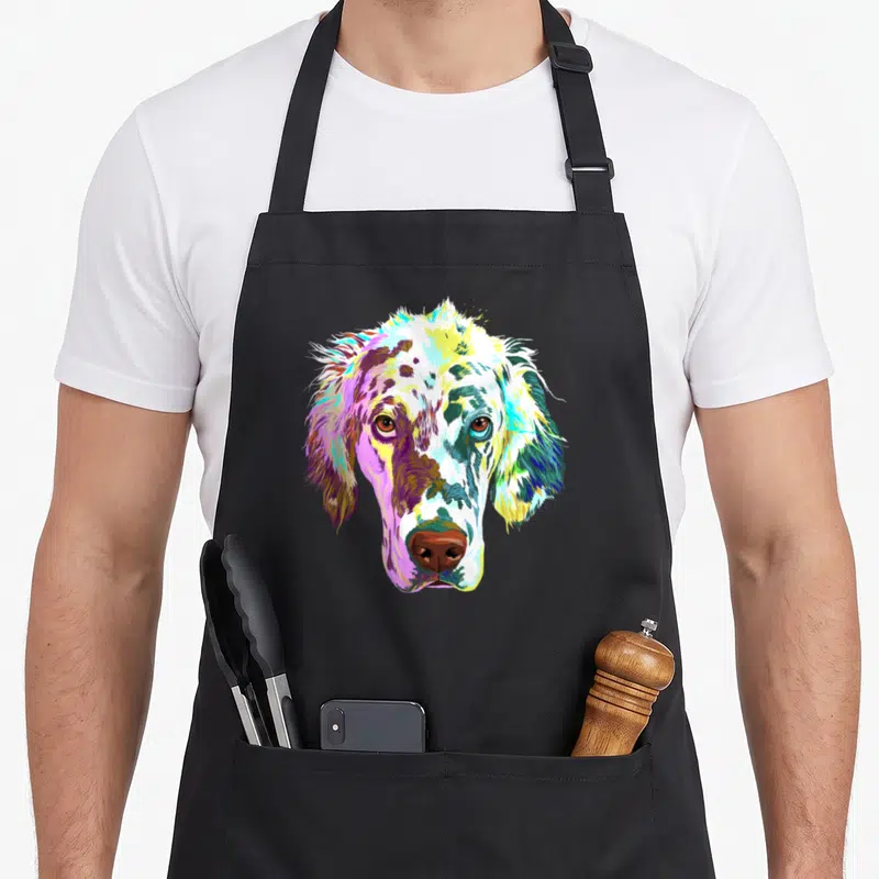 Colorful splash dog apron - Multicolored watercolor English Setter dog head print in yellow blue pink purple green brown — shown on a black cotton canvas apron against a white background