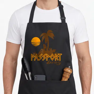 Bro meme apron - Orange sun and brown woman silhouette under palm tree with PASSPORT bros text — shown on a black cotton canvas apron against a white background