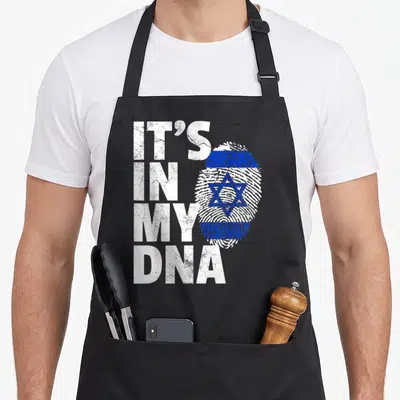 Israeli pride apron - IT'S IN MY DNA text next to a fingerprint shaped as the Israeli flag in blue and white — shown on a black cotton canvas apron against a white background