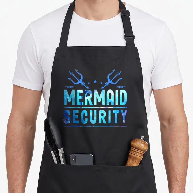 Security squad family aprons - MERMAID SECURITY text with two blue tridents and stars in watercolor style — shown on a black cotton canvas apron against a white background