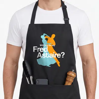 Fred ballroom apron - Dancing couple silhouettes in blue and orange with Will you be my Fred Astaire text in white — shown on a black cotton canvas apron against a white background