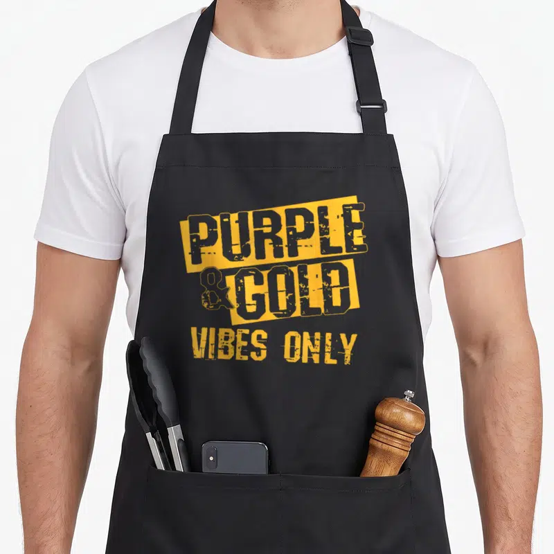School football apron - Yellow blocks with grey text reading purple and gold vibes only on grey background — shown on a black cotton canvas apron against a white background