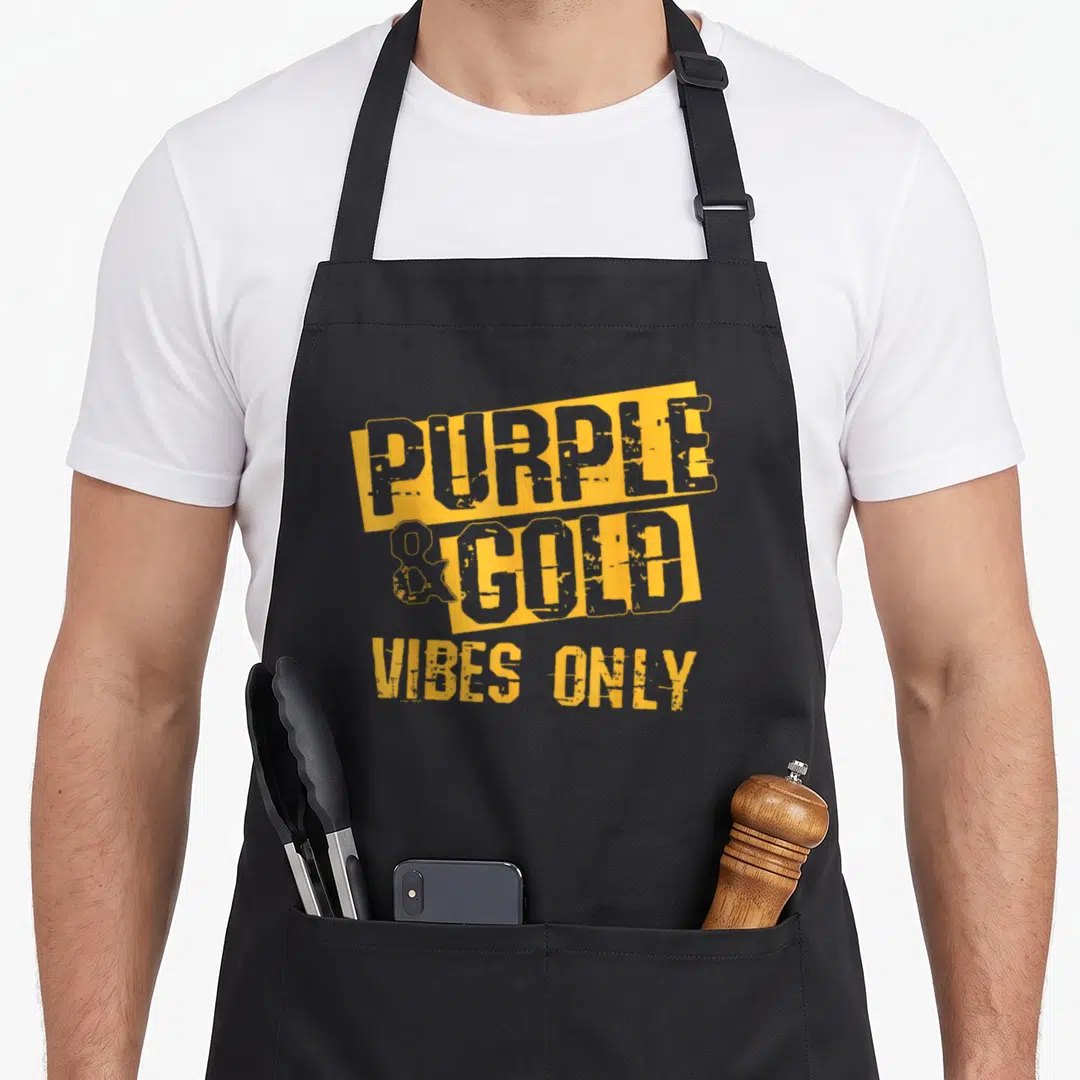 School football apron - Yellow blocks with grey text reading purple and gold vibes only on grey background — shown on a black cotton canvas apron against a white background